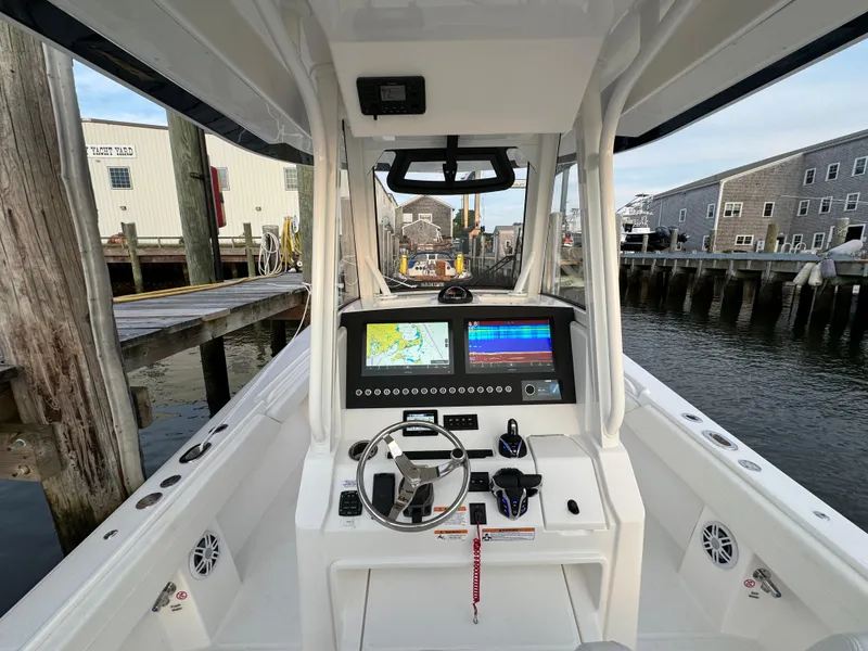 Slide: The Image of 2024 Regulator 28 boat cockpit with advanced navigation system at a marina. - 24