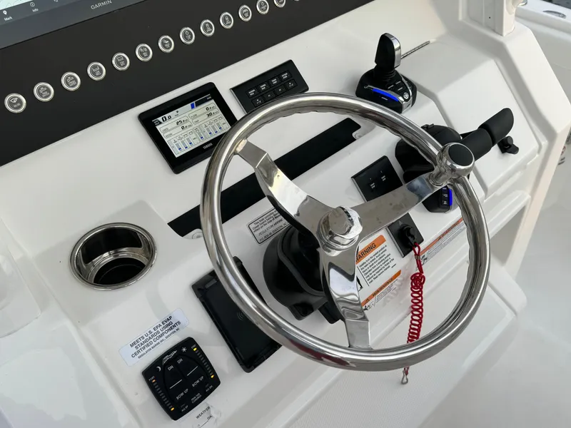 Slide: The Image of 2024 Regulator 28 boat helm with steering wheel and control panel. - 28