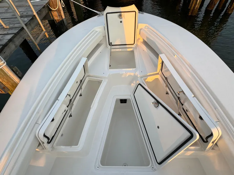 Slide: The Image of 2024 Regulator 28 boat with open storage compartments on deck. - 35