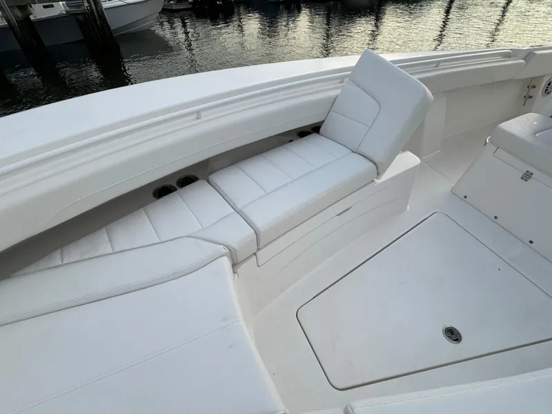 Slide: The Image of 2024 Regulator 28 boat with white cushioned seating, docked by the water. - 39