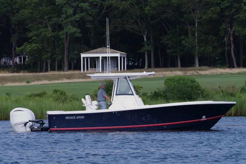 Slide: The Image of 2024 Regulator 28 boat on water near a grassy shoreline. - 4