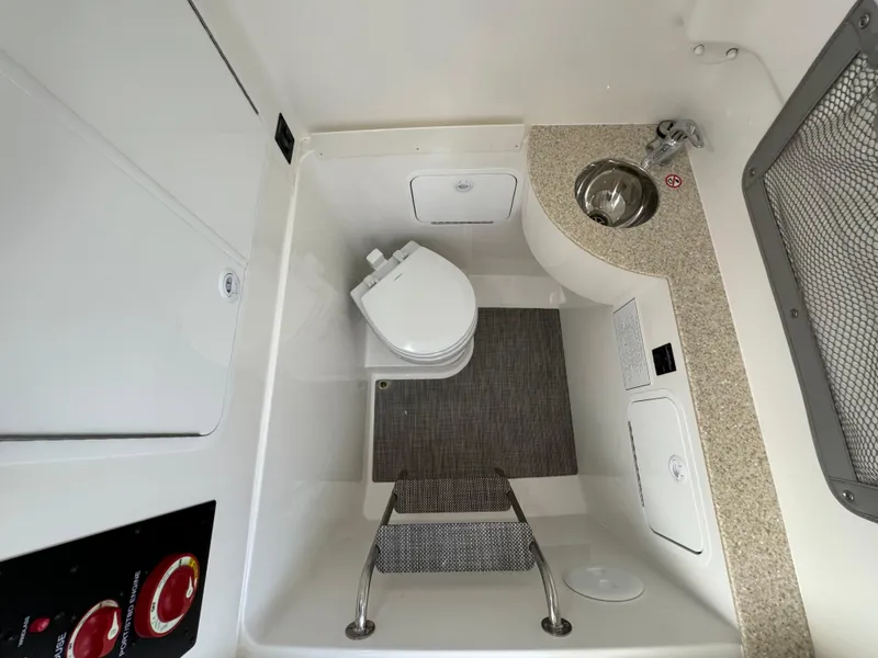 Slide: The Image of 2024 Regulator 28 boat interior with toilet, sink, and storage compartments. - 46