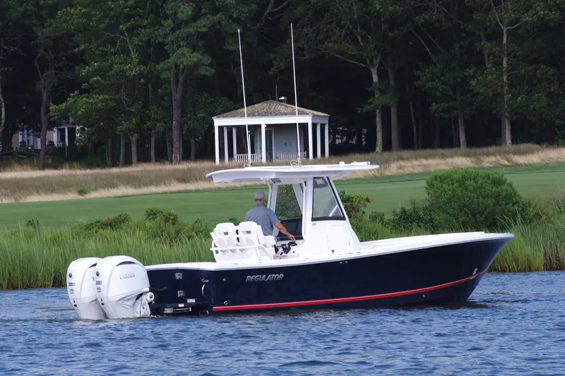 Slide: The Image of 2024 Regulator 28 boat cruising on a lake with a gazebo in the background. - 5