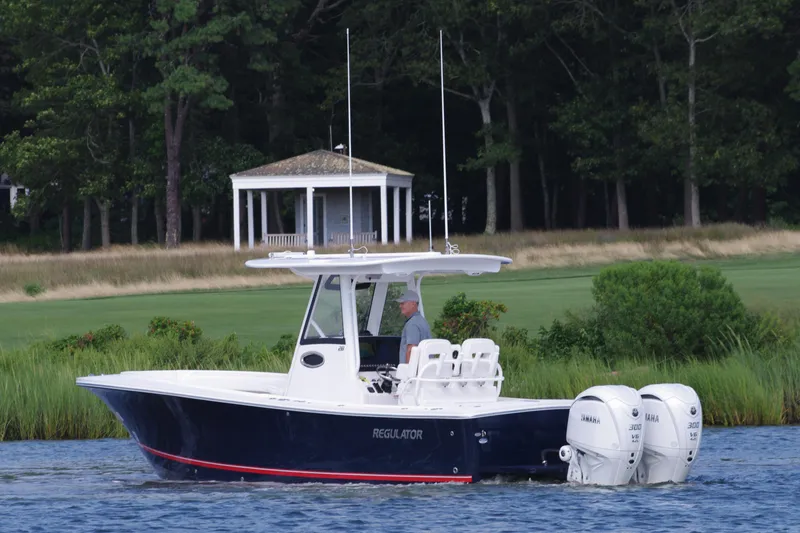 Slide: The Image of 2024 Regulator 28 boat cruising on a lake with a gazebo in the background. - 7