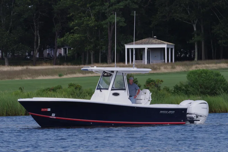 Slide: The Image of 2024 Regulator 28 boat cruising on a lake with a scenic backdrop. - 9