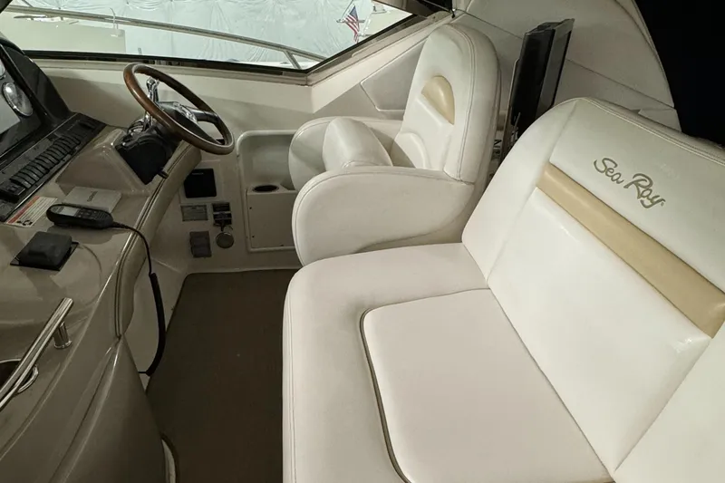 Slide: The Image of 2008 Sea Ray 38 Sundancer helm with white leather seats and modern controls. - 13
