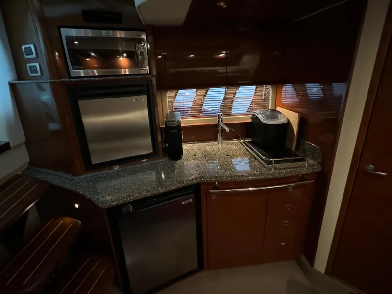 Slide: The Image of 2008 Sea Ray 38 Sundancer galley with modern appliances and granite countertops. - 23