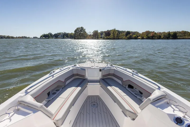 Slide: The Image of 2024 Solara 250 CW boat cruising on a sunny lake with scenic shoreline. - 17
