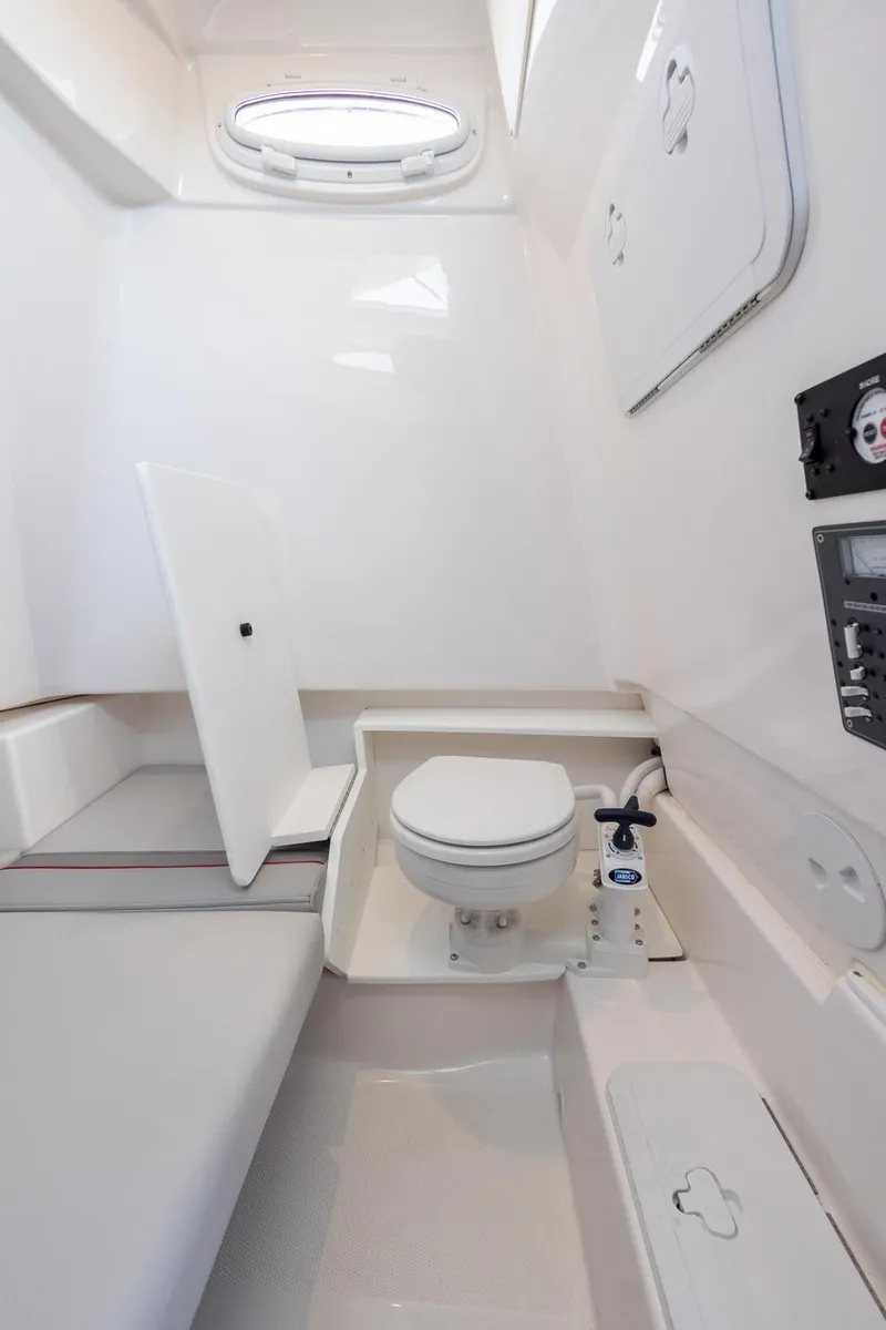 Slide: The Image of 2024 Solara 250 CW boat interior with compact marine toilet and seating area. - 25