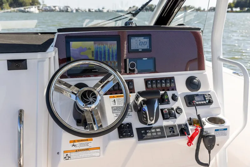 Slide: The Image of 2024 Solara 250 CW boat dashboard with steering wheel, navigation screens, and control panel. - 7