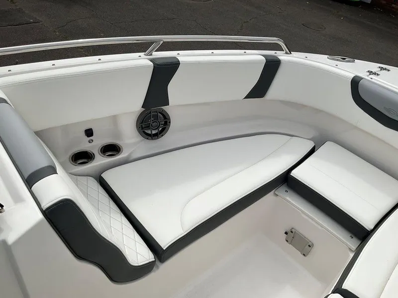 Slide: The Image of 2024 Chaparral 250 OSX boat interior with white and gray seating, cup holders, and speaker. - 13