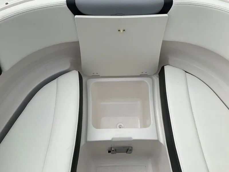 Slide: The Image of 2024 Chaparral 250 OSX boat interior with storage compartment and white seating. - 15