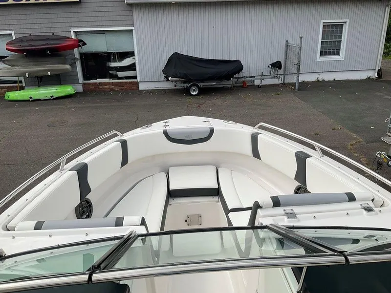 Slide: The Image of 2024 Chaparral 250 OSX boat with spacious seating in a marina setting. - 18