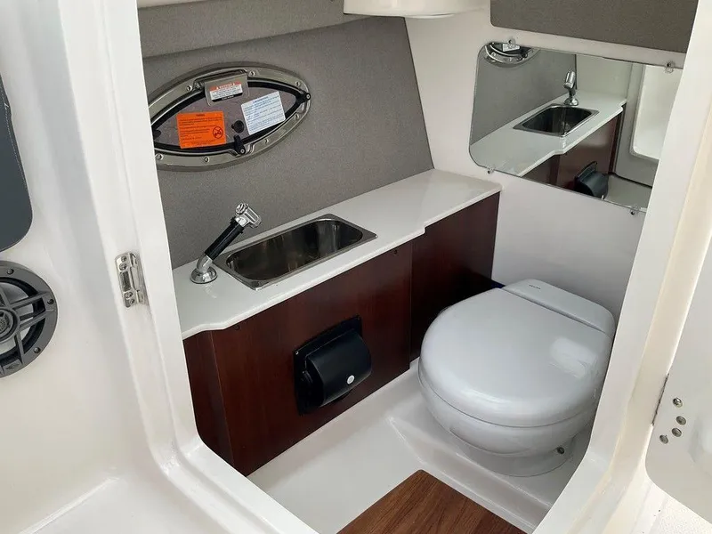 Slide: The Image of 2024 Chaparral 250 OSX boat interior with sink and toilet. - 27