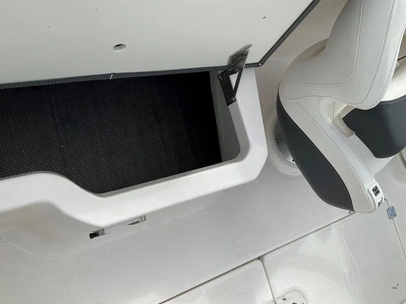 Slide: The Image of 2024 Chaparral 250 OSX boat interior storage compartment and seating detail. - 33