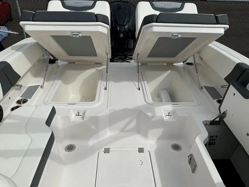Slide: The Image of 2024 Chaparral 250 OSX boat with open storage compartments and seating. - 35