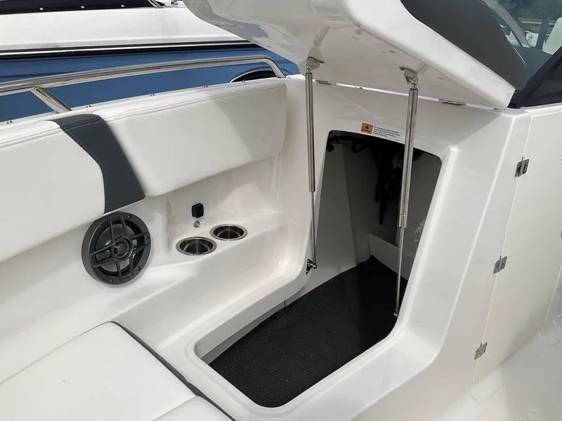 Slide: The Image of 2024 Chaparral 250 OSX boat interior with storage compartment and cup holders. - 36
