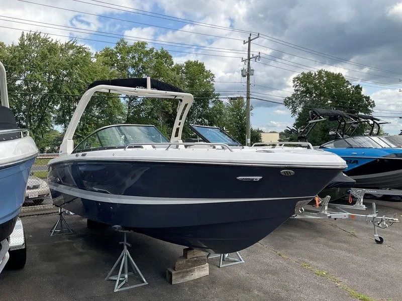 Slide: The Image of 2024 Chaparral 250 OSX boat displayed outdoors on stands. - 4