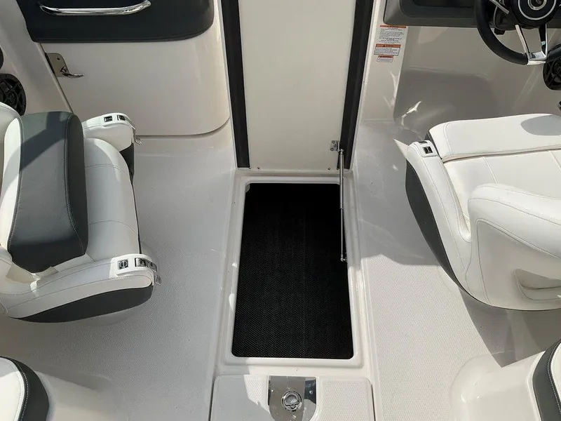 Slide: The Image of 2024 Chaparral 250 OSX boat interior with white seating and storage compartment. - 40