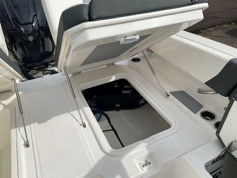 Slide: The Image of 2024 Chaparral 250 OSX boat storage compartment open, showcasing interior features. - 41