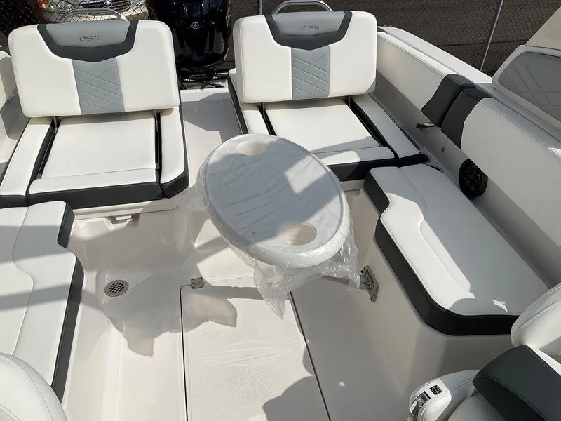 Slide: The Image of 2024 Chaparral 250 OSX boat interior with white and gray seating and a central table. - 45