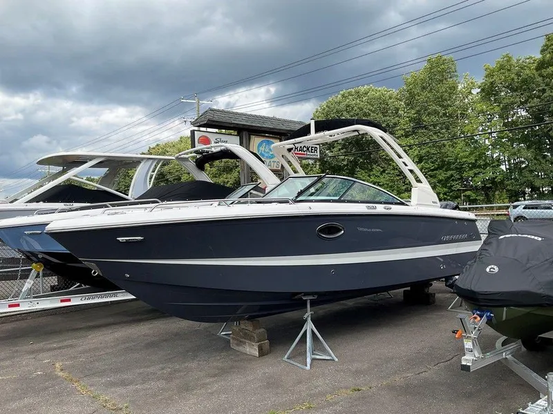 Slide: The Image of 2024 Chaparral 250 OSX boat displayed outdoors on a stand under cloudy skies. - 5