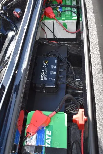 Slide: The Image of 2024 Triton 18 TrX boat battery compartment with NOCO Genius charger. - 29