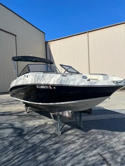 The Image of 2020 Stingray 201 DS boat on a trailer outside a warehouse. - 0
