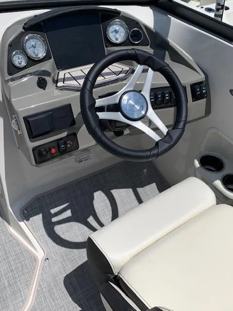 Slide: The Image of 2020 Stingray 201 DS boat cockpit with steering wheel and control panel. - 12