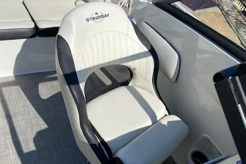 Slide: The Image of Captain's chair in a 2020 Stingray 201 DS boat, featuring white and black upholstery. - 20
