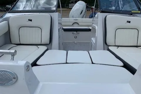 Slide: The Image of 2020 Stingray 201 DS boat interior with white cushioned seating and outboard motor. - 26