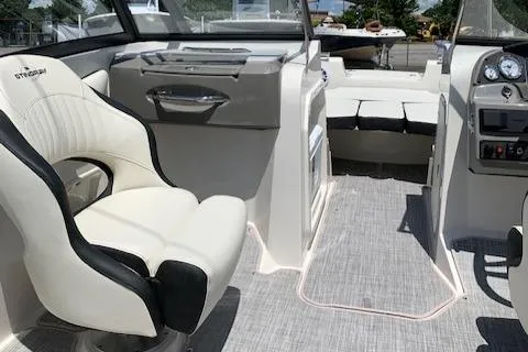 Slide: The Image of 2020 Stingray 201 DS boat interior with white and black seating, dashboard, and open deck. - 28
