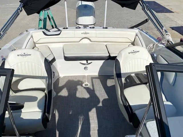 Slide: The Image of 2020 Stingray 201 DS boat interior with white seating and steering console. - 9