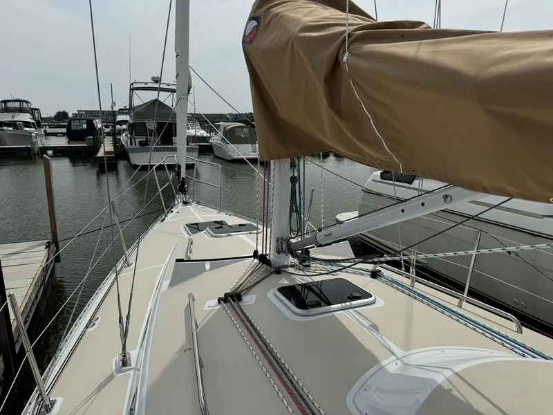 Slide: The Image of 2025 Tartan 365 sailboat docked at marina, featuring beige deck and covered mast. - 10