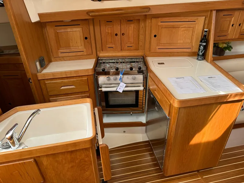 Slide: The Image of Modern Tartan 365 yacht kitchen with wooden cabinetry and stainless steel appliances, 2025 model. - 16