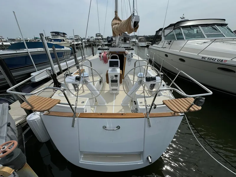 Slide: The Image of 2025 Tartan 365 sailboat docked at marina, showcasing sleek design and dual steering wheels. - 4