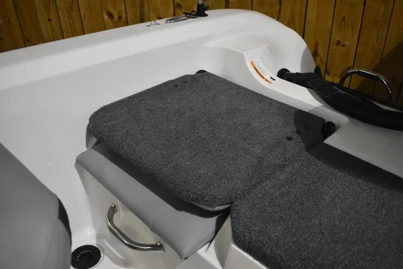 Slide: The Image of Interior seating of 2024 Triton 186 Allure boat with gray upholstery and wooden backdrop. - 110