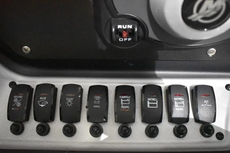 Slide: The Image of Control panel of 2024 Triton 186 Allure boat with various switches and a run/off toggle. - 119