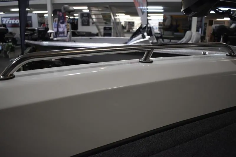 Slide: The Image of 2024 Triton 186 Allure boat deck with textured gray surface and circular latch. - 18