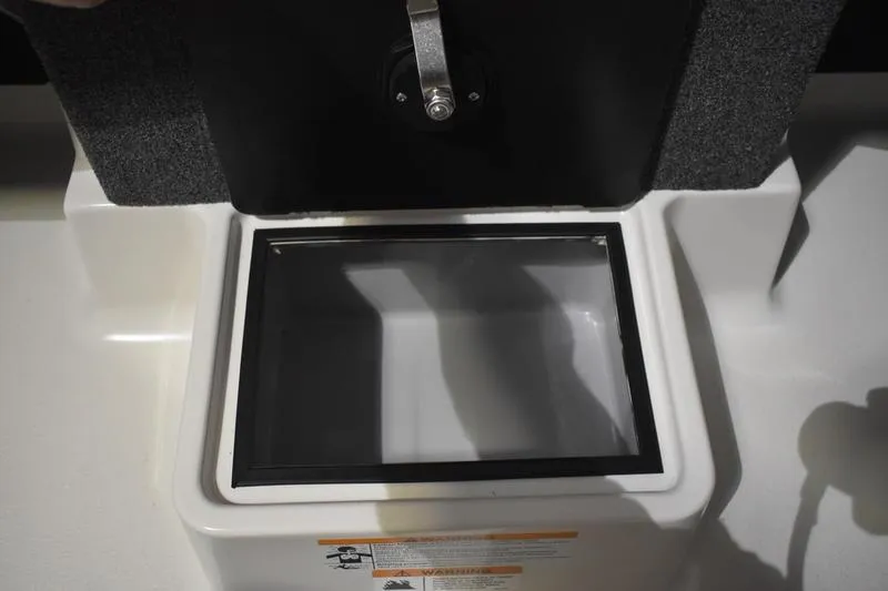 Slide: The Image of Open storage compartment in 2024 Triton 186 Allure boat, featuring a secure latch. - 21