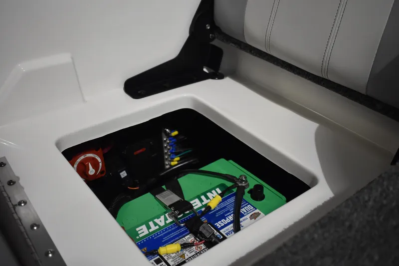 Slide: The Image of 2024 Triton 186 Allure boat battery compartment with green battery and wiring. - 60