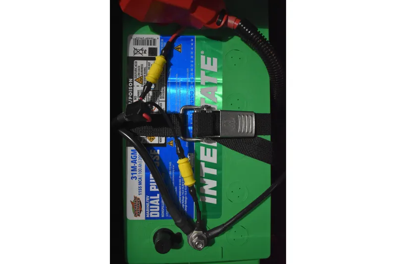 Slide: The Image of 2024 Triton 186 Allure boat battery, Interstate brand, secured with cables and strap. - 62