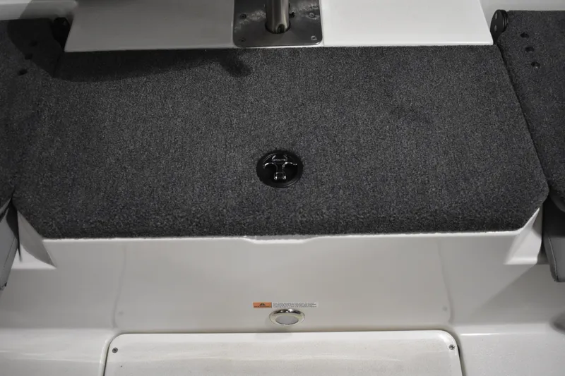 Slide: The Image of 2024 Triton 186 Allure boat deck with gray carpet and storage compartment. - 63