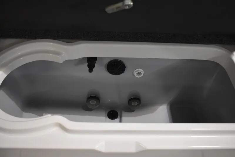 Slide: The Image of 2024 Triton 186 Allure boat livewell interior with drain and fittings. - 65