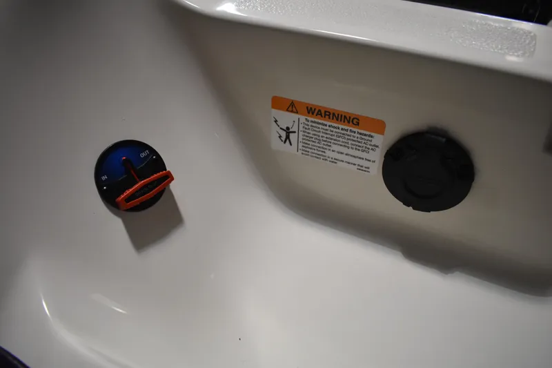 Slide: The Image of 2024 Triton 186 Allure boat control panel with warning label and dial. - 74