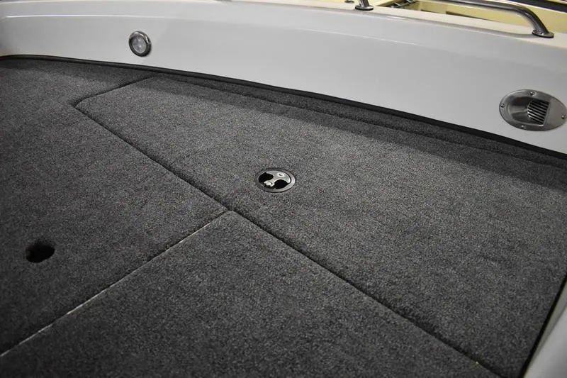 Slide: The Image of 2024 Triton 186 Allure boat interior with carpeted deck and storage compartment. - 82