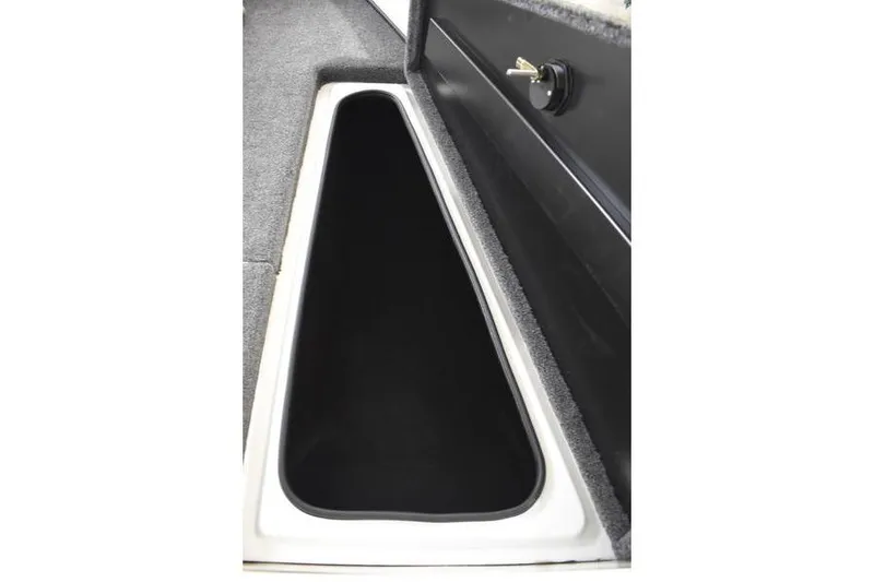 Slide: The Image of 2024 Triton 186 Allure boat storage compartment with secure lock and carpeted interior. - 87