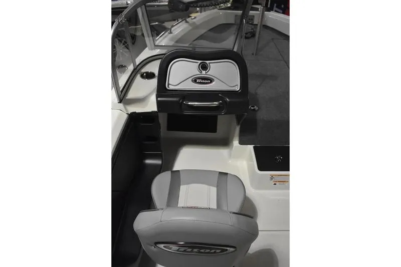 Slide: The Image of 2024 Triton 186 Allure boat interior with steering console and cushioned seat. - 91