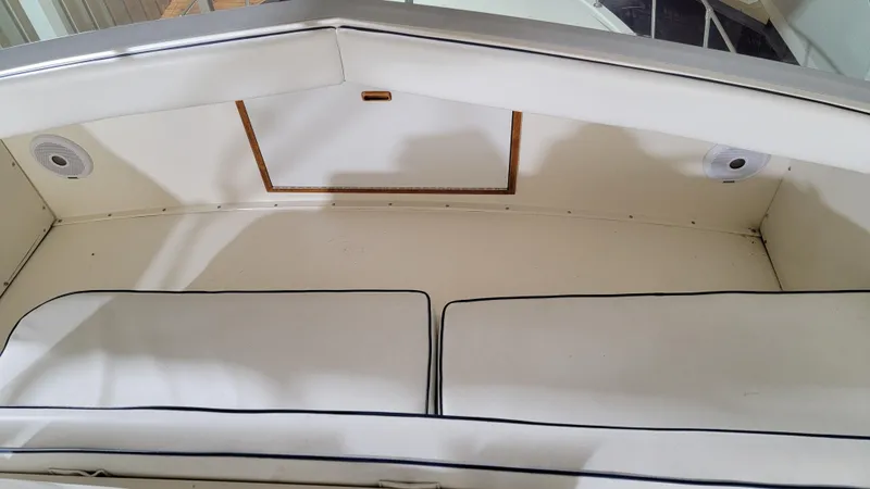 Slide: The Image of Interior seating area of a 1983 Bertram 33 Flybridge Cruiser with white cushions. - 14