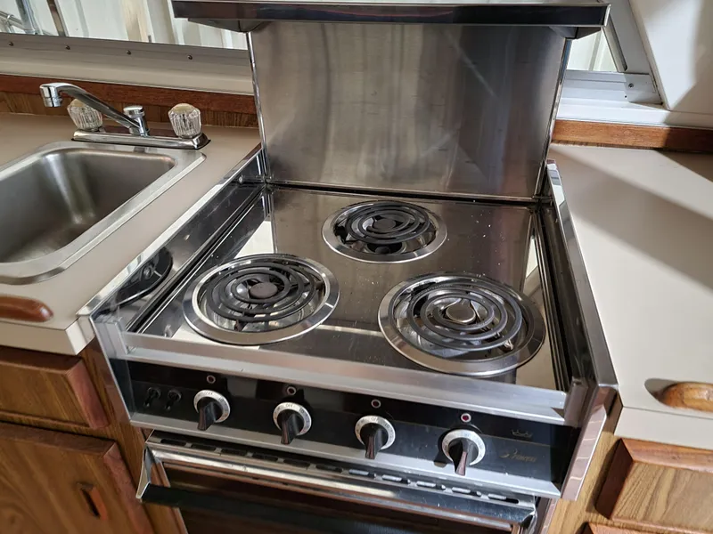 Slide: The Image of Stainless steel stove and sink in 1983 Bertram 33 Flybridge Cruiser kitchen. - 20